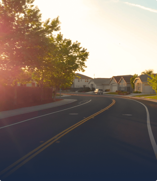 Winding road in front of some houses during golden hour