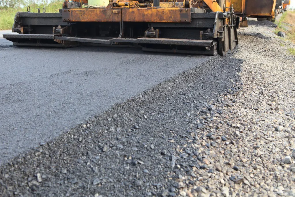 asphalt paver paving down a road