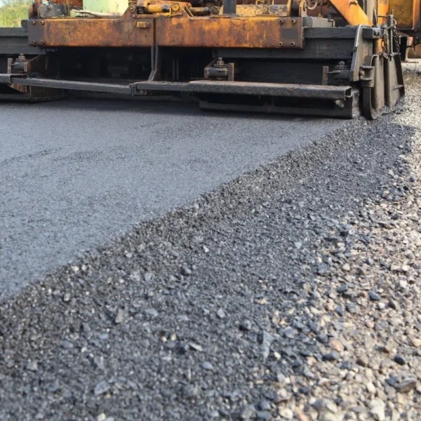 asphalt paver paving down a road