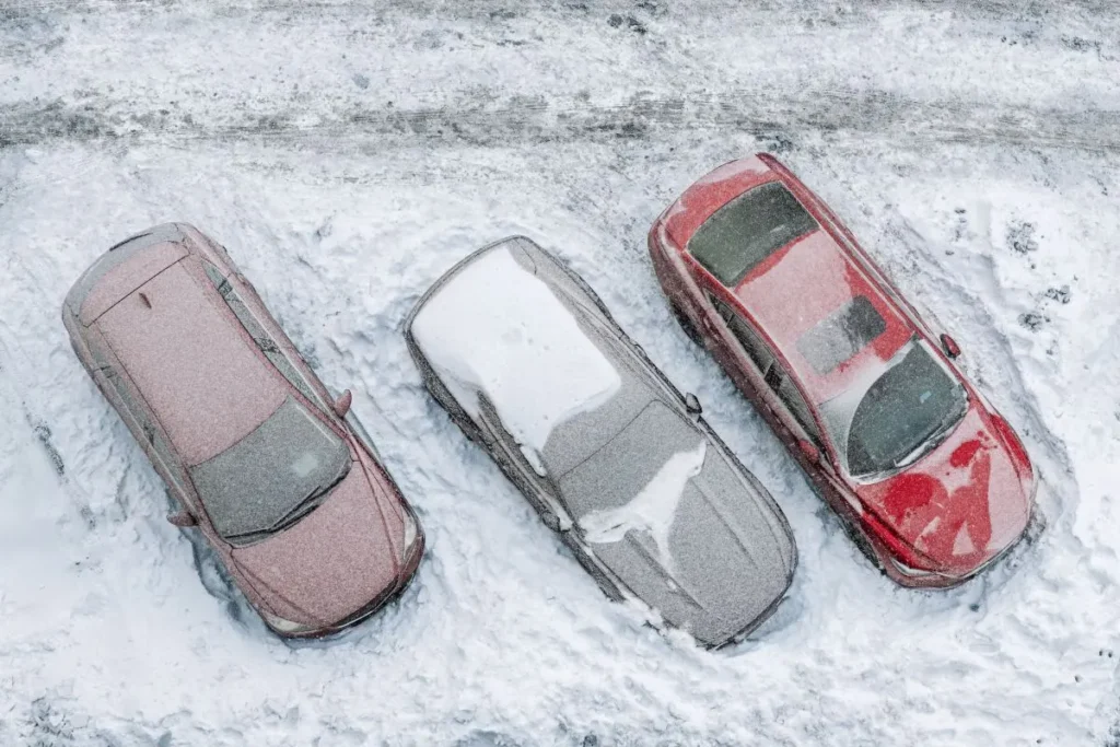 three cars in a snowy parking lot