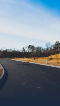 Winding asphalt road in middle of dirt field