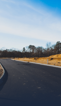 Winding asphalt road in middle of dirt field Winding asphalt road in middle of dirt field