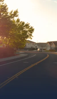 Winding road in front of some houses during golden hour