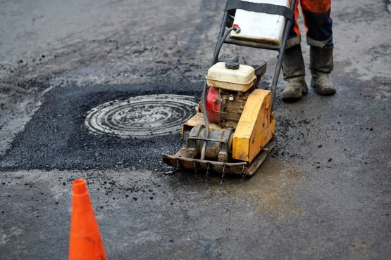 patching asphalt around a manhole cover